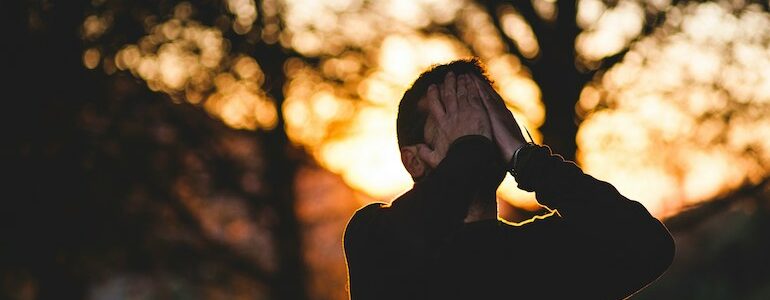 man in a black shirt looking worries and exhausted