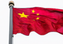 A Chinese flag flies on a high pole